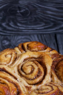 Pişmiş tarçınlı kek. Siyah kompozit tahtaların üzerinde dur. Yakın çekim..