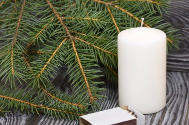 Firavun dalları ve siyah çam ağaçlarında bir mum.