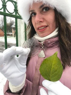 Kız elinde yeşil bir çarşaftan alınmış bir buz parçası tutuyor. Yakın çekim..