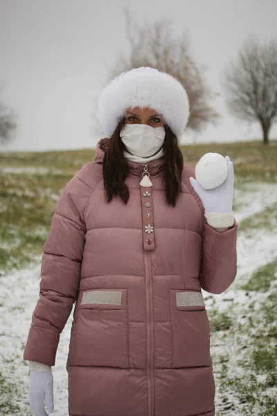 Девушка Медицинской Маске Зимней Одежде Прогулке Парке Держит Шар Снега — стоковое фото
