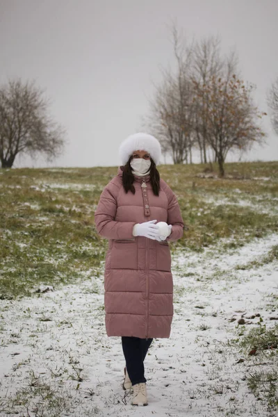 Дівчина Медичній Масці Прогулянку Тримає Руках Снігу Земля Покрита Першим — стокове фото