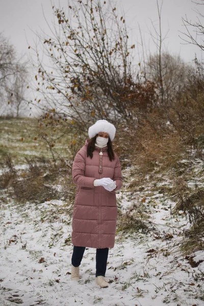 Девушка Медицинской Маске Прогулке Держит Снежный Шар Ладонях Земля Покрыта — стоковое фото