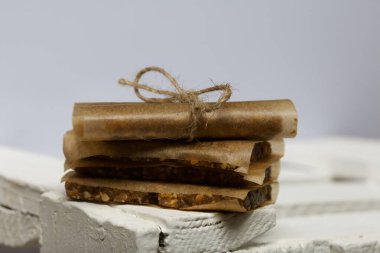 Ev yapımı fındık ve kurutulmuş meyveli çikolatalar. Kağıda sarılmış ve sicimle bağlanmış. Beyaz ahşap bir kutuda.