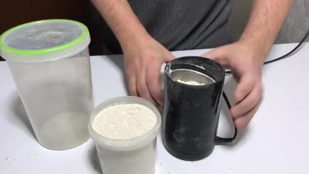 Um homem faz farinha de aveia num moedor de café. Farinha de aveia. Imagem de close-up. — Vídeo de Stock