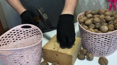 Adam ceviz kırıyor. Tahta bir takozda çekiç. Yakın çekim..