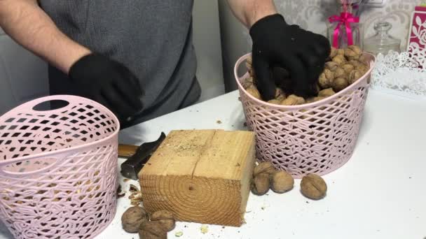 Muž píchne kladivem vlašské ořechy. Na dřevěném bloku. — Stock video