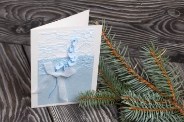 Mavi gözlüklü tebrik kartı. Spruce şubesi. Simsiyah tahtalar üzerinde,.