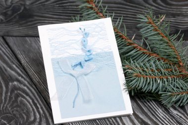 Mavi gözlüklü tebrik kartı. Spruce şubesi. Simsiyah tahtalar üzerinde,.