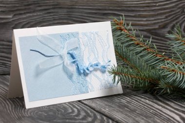 Mavi gözlüklü tebrik kartı. Spruce şubesi. Simsiyah tahtalar üzerinde,.