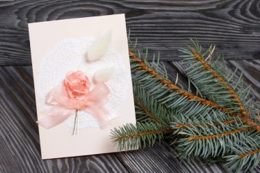 Pembe gözlüklü tebrik kartı. Spruce şubesi. Simsiyah tahtalar üzerinde,.