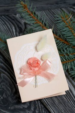 Pembe gözlüklü tebrik kartı. Spruce şubesi. Simsiyah tahtalar üzerinde,.