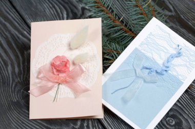 Mavi ve pembe tonları olan tebrik kartları. Spruce şubesi. Simsiyah tahtalar üzerinde,.