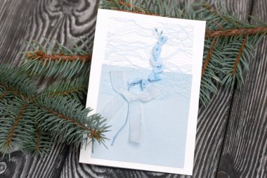 Mavi gözlüklü tebrik kartı. Spruce şubesi. Simsiyah tahtalar üzerinde,.