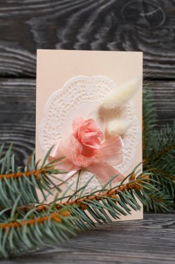 Pembe gözlüklü tebrik kartı. Spruce şubesi. Simsiyah tahtalar üzerinde,.