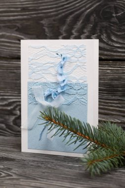 Mavi gözlüklü tebrik kartı. Spruce şubesi. Simsiyah tahtalar üzerinde,.