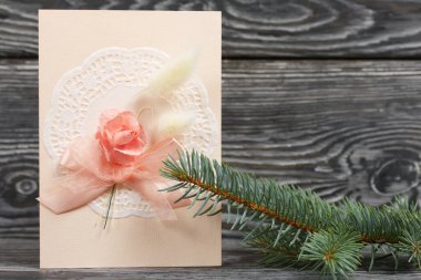 Pembe gözlüklü tebrik kartı. Spruce şubesi. Simsiyah tahtalar üzerinde,.