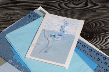 Mavi gözlüklü tebrik kartı. Kartpostal yapmak için malzemeler. Simsiyah tahtalar üzerinde,.