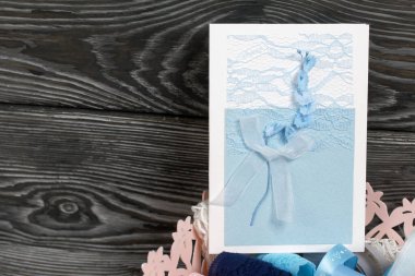 Mavi gözlüklü tebrik kartı. Kartpostal yapmak için malzemeler. Simsiyah tahtalar üzerinde,.