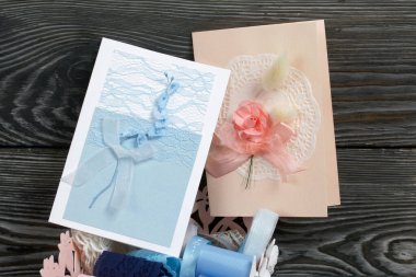 Mavi ve pembe tonları olan tebrik kartları. Kartpostal yapmak için malzemeler. Simsiyah tahtalar üzerinde,.