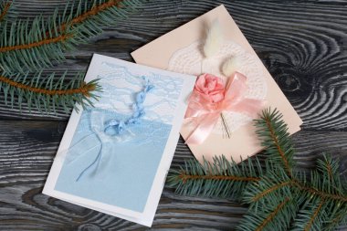 Mavi ve pembe tonları olan tebrik kartları. Spruce şubesi. Simsiyah tahtalar üzerinde,.
