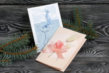 Mavi ve pembe tonları olan tebrik kartları. Spruce şubesi. Simsiyah tahtalar üzerinde,.