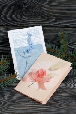Mavi ve pembe tonları olan tebrik kartları. Spruce şubesi. Simsiyah tahtalar üzerinde,.