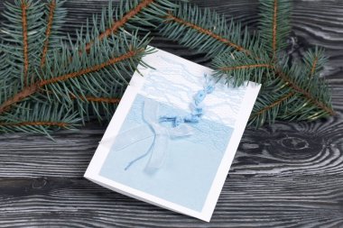 Mavi gözlüklü tebrik kartı. Spruce şubesi. Simsiyah tahtalar üzerinde,.