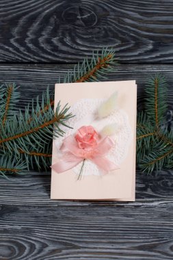 Pembe gözlüklü tebrik kartı. Spruce şubesi. Simsiyah tahtalar üzerinde,.