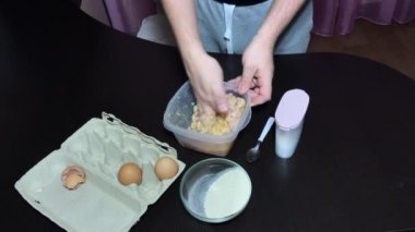Bir adam pirzola için kıyma hazırlar. Ete yumurta ve ekmek kırıntıları ekler. Elle karıştırır