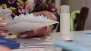 Bir kadın tebrik kartı yapar. Kadını onun ellerinde muayene ediyor. Yakın plan..