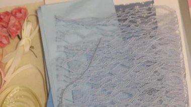 Masadaki kadın bir tebrik kartı yapıyor. Kağıt elementleri yapıştırır. Yukarıdan çekilen.