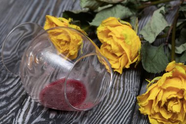 Bir buket kurutulmuş sarı gül. Devrilmiş bir bardak ekşi şarap. Çam ağacında.