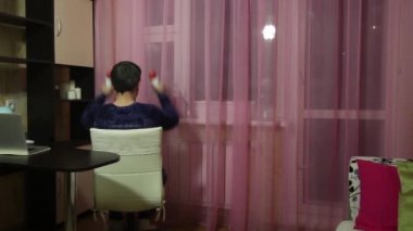 Tıbbi maskeli bir adam kendini izole ederek jimnastik yapar. Dambıl yerine konserve deterjan. İki elinizi başınızın arkasına koyup triseps için halterleri kaldırın. Arkadan çekilmiş..