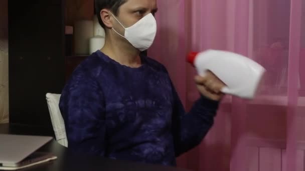 Un bărbat cu o mască medicală face gimnastică în auto-izolare. În loc de gantere, cutii de detergent. Scaun alternativ biceps gantere lift . — Videoclip de stoc