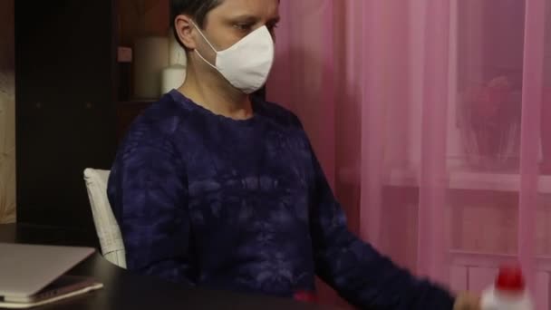 Ein Mann mit medizinischer Maske turnt in Selbstisolierung. Statt Hanteln Dosen mit Waschmittel. Sitzende Hantelrolle. — Stockvideo