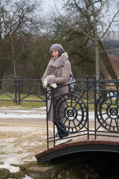 Дівчина Зимовому Одязі Гуляє Парку Позування Пішохідному Мосту — стокове фото
