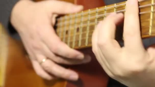 Een man speelt een zes snarige akoestische gitaar. Speelt verschillende akkoorden. — Stockvideo