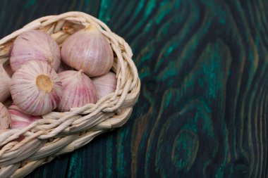 Hasır sepette sarımsak. Yeşil çam ağaçlarının üzerinde. Yakın çekim..