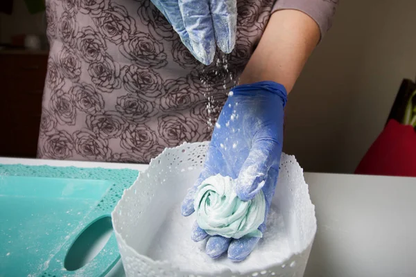 戴橡胶手套的女人做棉花糖 用糖粉撒在上面 甜点放在桌子的表面上 — 图库照片