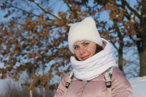 Portrait of a girl in winter clothes. In the winter park. Face close-up.