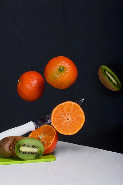 Tangeriner Och Kiwis Flyter Ovanför Bordsytan Vissa Sönderskurna Levitation Frukt — Stockfoto