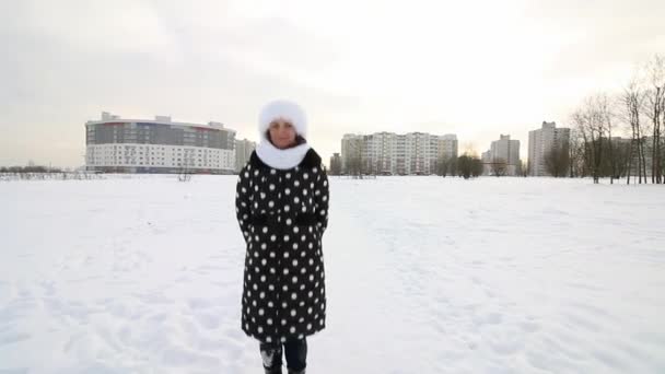 The girl walks through the winter wasteland. Jumps up, basking in the cold. There is a lot of snow around. — Stock Video