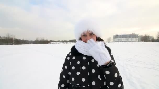 Dziewczyna przechadza się po zimowych pustkowiach. Uśmiechy i gesty. Wokół jest dużo śniegu.. — Wideo stockowe