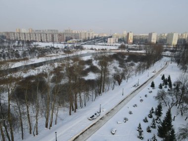 Yukarıdan kentsel kış manzarası. Şehir parkındaki çok katlı binalar ve ağaçlar görülebilir..