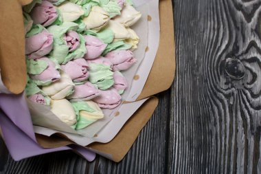 Zephyr buketi. Marshmallow laleleri bir bukette toplanır ve el sanatları kağıdına sarılır. Çam ağacının üzerinde yatıyor.