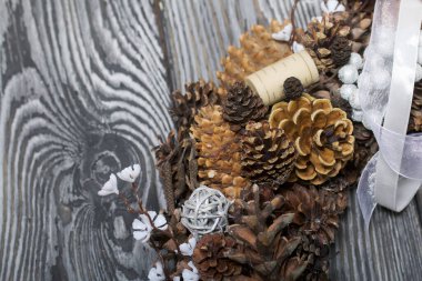 Bir koni çelengi, şarap mantarı ve dekoratif elementler. Çam ağacının üzerinde yatıyor. Yakın çekim..