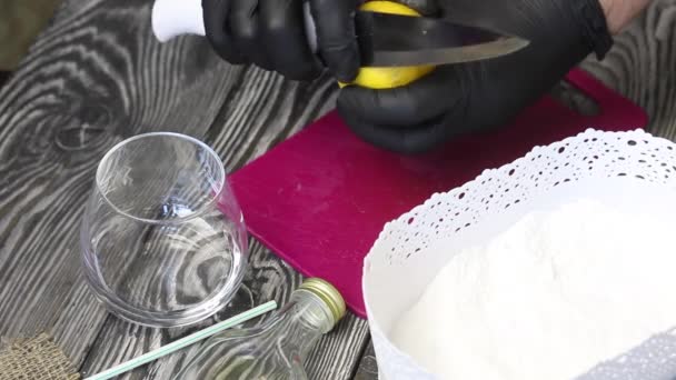 Ο άνθρωπος κόβει ένα λεμόνι. Ετοιμάζει μιλκσέικ ακτινίδιο. Ζάχαρη σε σκόνη κοντά — Αρχείο Βίντεο