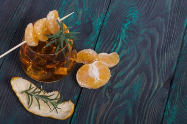 Alkolik kokteyl. Biberiye dilimleri ve mandalina dilimleriyle süslenmiş. Yakın çekim..