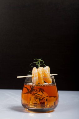Alkolik kokteyl. Biberiye dilimleri ve mandalina dilimleriyle süslenmiş. Yakın çekim..