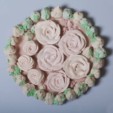 Zephyr buketi. Marshmallow laleleri bir bukette toplanır ve kağıda sarılır. Masada zephyr gülleri var..